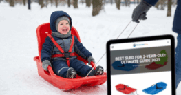 2-jähriges Kind sitzt sicher angeschnallt in einem roten Kleinkind-Schlitten im Schnee - Illustration für den Ratgeber ‘Bester Schlitten für 2-jährige Kinder 2025’.